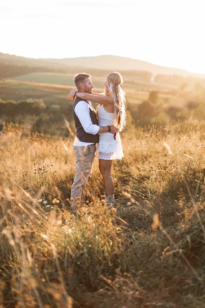 Boho ypsy femme et homme posant dans le champ de l'été