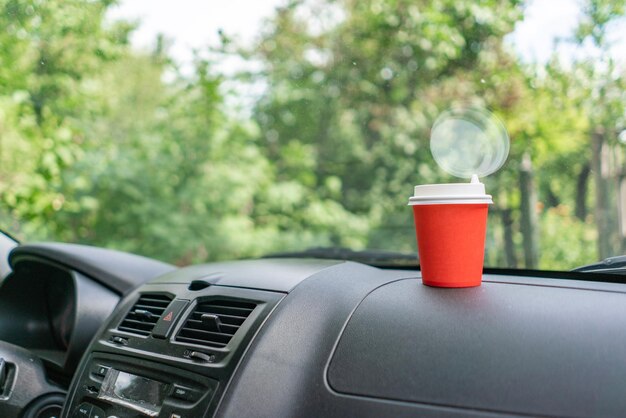 Boire du café dans une tasse en papier pendant le trajet en voiture