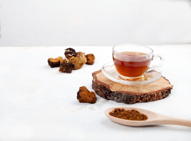 Photo boire du café sain à partir de champignons chaga dans une tasse en verre sur fond blanc vue de dessus copt spaes