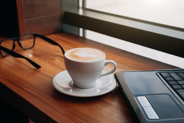 Boire du café en utilisant un ordinateur portable au café