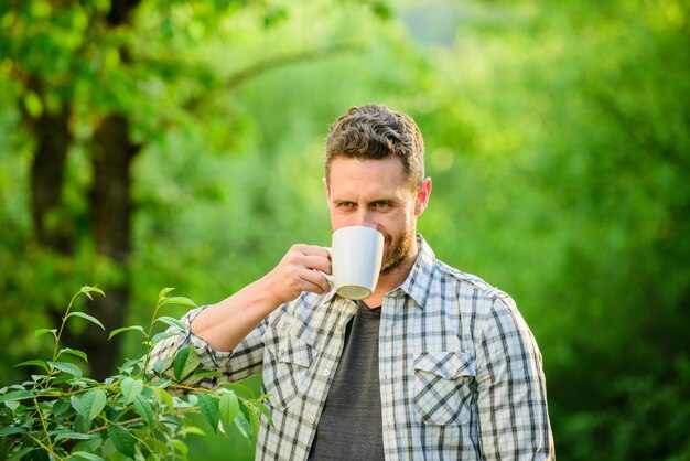 Boire du thé en plein air café du matin mode de vie sain nature et santé petit déjeuner temps de rafraîchissement vie écologique pour homme homme dans la forêt verte homme heureux avec une tasse de thé profiter du café du matin