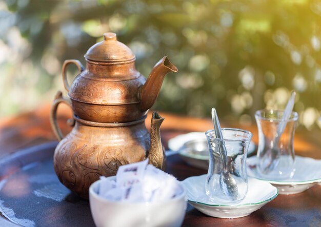 Boire du thé turc traditionnel avec une tasse de thé turque et une théière en cuivre