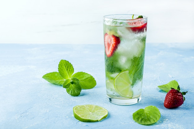 boire avec de la fraise, du citron vert et de la menthe. limonades d'été ou thé glacé. Cocktails mojito avec des glaçons.