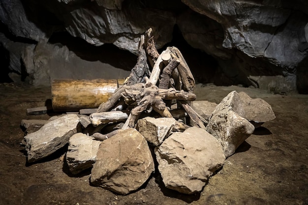 Bois de chauffage en bois dans un incendie dans une grotte Reconstitution de la vie d'un homme des cavernes