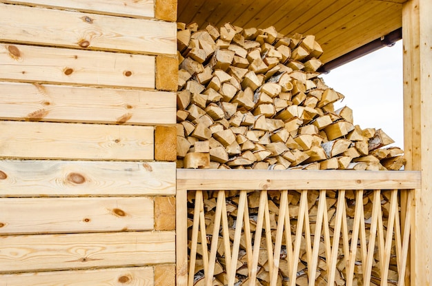 Bois de chauffage empilé sur la véranda de la maison.