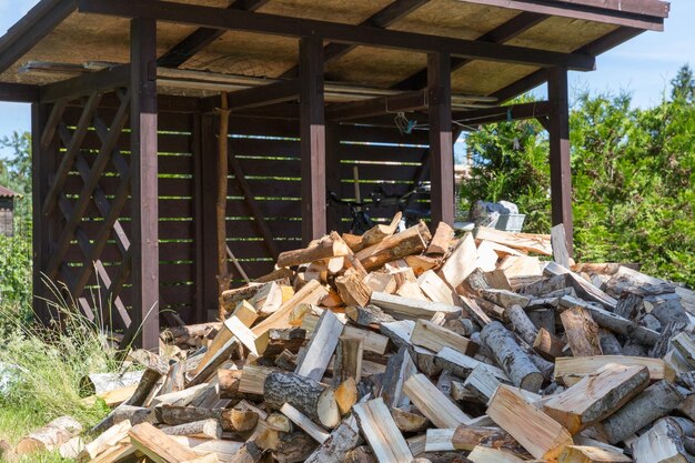 Photo bois de chauffage récolté pour le chauffage en hiver pile de bois de chauffe dans la cour de la maison sur l'herbe verte