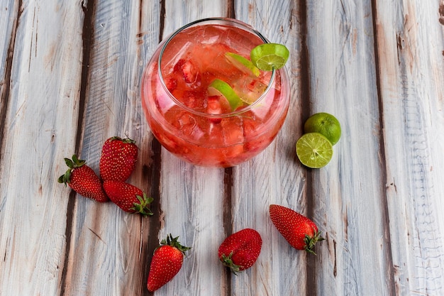 Boisson aromatisée à la fraise servie dans un grand bocal à poissons sur une table de restaurant