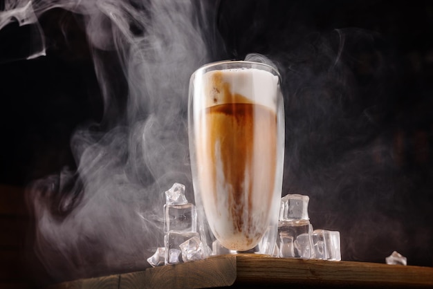 Boisson au café avec de la crème et de la glace sur un fond en bois foncé