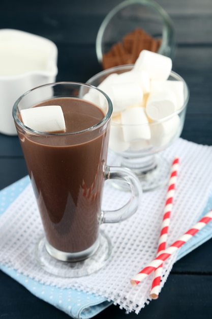 Boisson au chocolat avec des guimauves dans une tasse, sur fond de bois