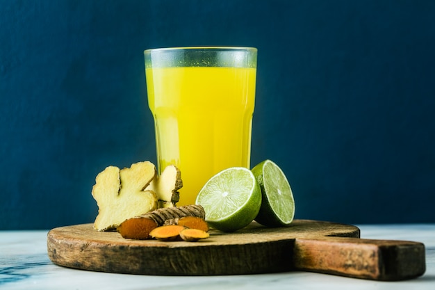 Boisson au gingembre et curcuma doré avec du jus de citron vert. Boisson saine anti-inflammatoire de médecine naturelle et de naturopathie