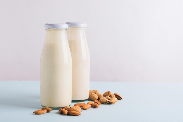 Boisson au lait de noix d'amande dans des bouteilles en verre fond clair Le concept de régime alimentaire sain espace de copie de cadre horizontal