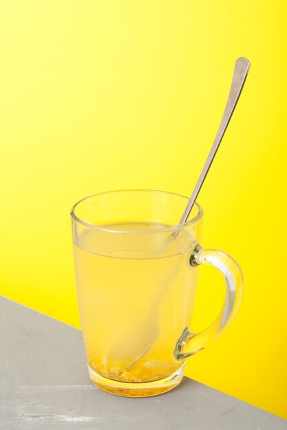 Boisson au miel et citron dans une tasse en verre avec cuillère