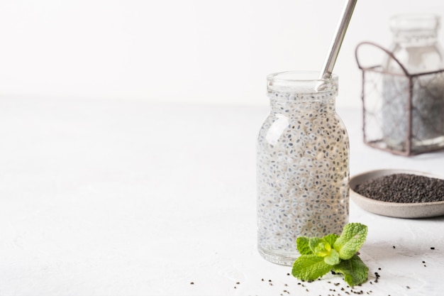 Boisson aux graines de basilic sucré avec de l'eau en verre sur blanc. Fermer.