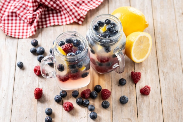 Boisson de baies fraîches avec des bleuets et des framboises sur une table en bois