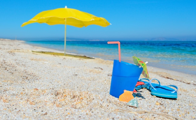 Boisson bleue et parasol jaune sur une plage tropicale