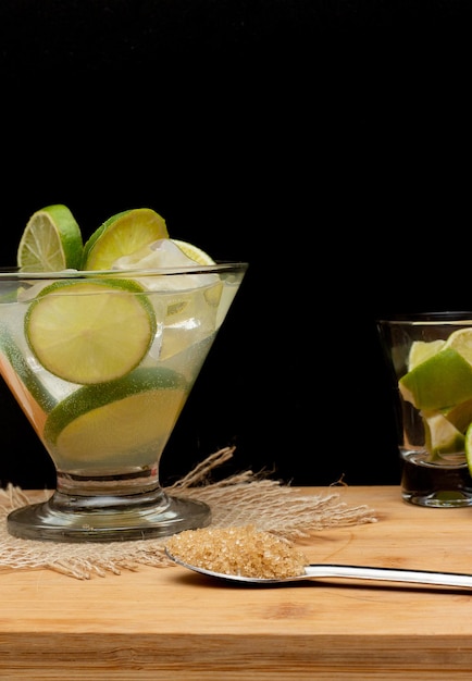 Boisson brésilienne caipirinha avec du sucre et des ingrédients autour