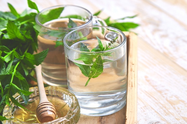 Boisson chaude au thé à la menthe et aux herbes dans une tasse en verre