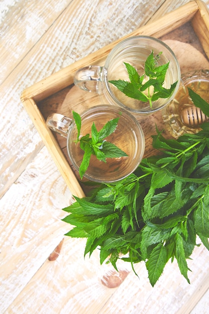 Boisson chaude au thé à la menthe et aux herbes dans une tasse en verre