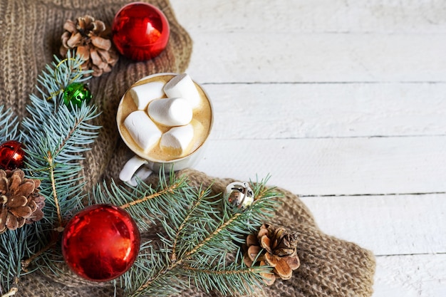 Boisson chaude d'hiver. Chocolat chaud de Noël ou cacao à la guimauve sur fond blanc avec des jouets de Noël rouges et des pins. Vue de dessus avec l'arrière-plan de l'espace de copie