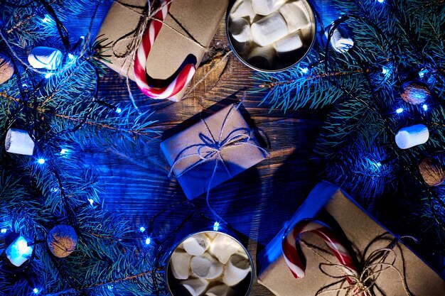 Boisson chaude de Noël cacao avec guirlande de guimauve et branches d'épinette sur une vue de dessus de fond en bois