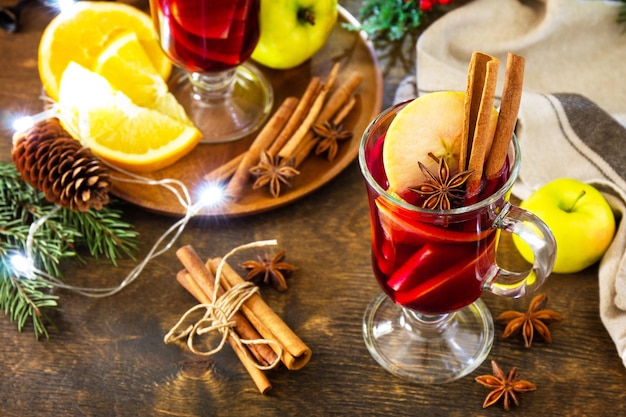 Boisson chaude de Noël d'hiver avec pomme orange et épices Vin chaud dans une tasse en verre avec épices