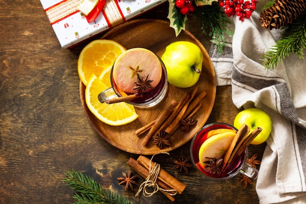 Boisson chaude de Noël d'hiver avec pomme orange et épices Vin chaud dans une tasse en verre avec épices