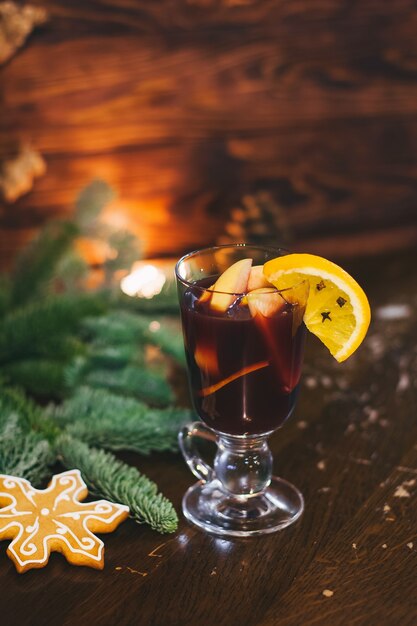 Boisson chaude rouge glintwein avec épices cannelle fruits anis cassonade sur une vieille table en bois