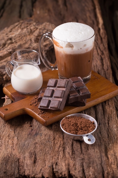 Boisson de chocolat au lait froid et barre de chocolat sur fond en bois