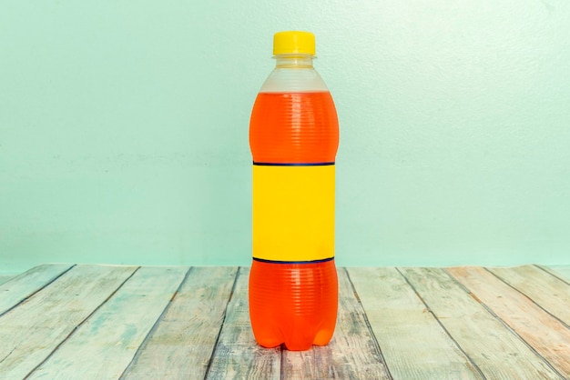 Boisson de couleur orange rafraîchissante dans un récipient en plastique sur une table en bois