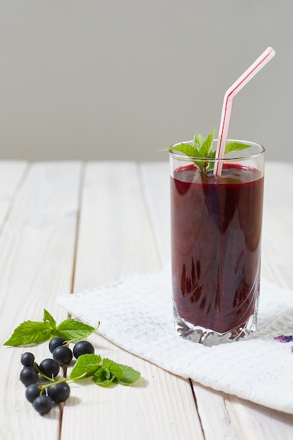 Boisson détox de baies de cassis sur un bois clair