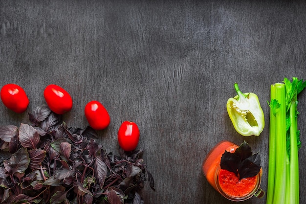 Boisson épicée à la tomate avec du céleri et du poivre boisson tomate en pot entouré de légumes frais sur un wo