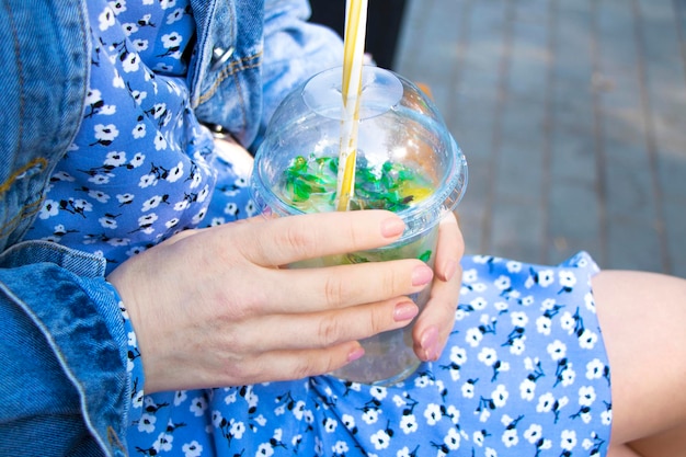 boisson d'été dans les mains des femmes mojito froid dans un cocktail non alcoolisé de rue en verre en plastique