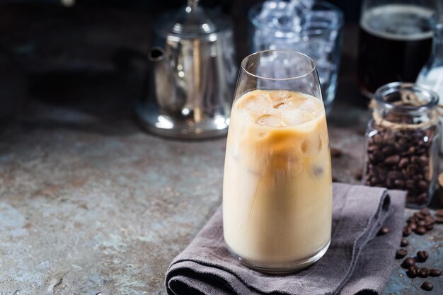 Boisson d'été froide au café glacé dans un grand verre et grains de café sur fond de pierre.