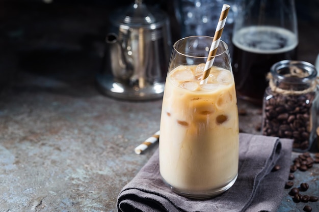 Boisson d'été froide au café glacé dans un grand verre et grains de café sur fond de pierre.