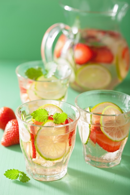 Boisson d'été rafraîchissante avec citron vert aux fraises en pot et verres