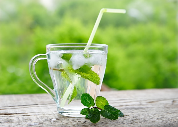 Boisson fraîche au citron et à la menthe dans un verre avec des pailles