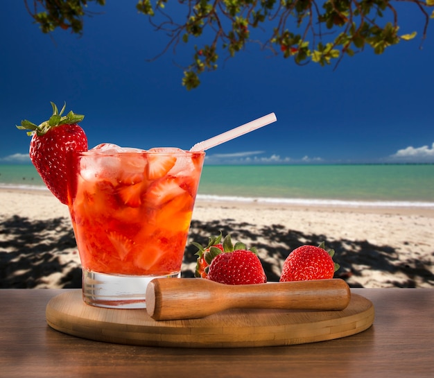 Boisson fraîche faite de Caipirinha aux fraises dans le fond de la plage