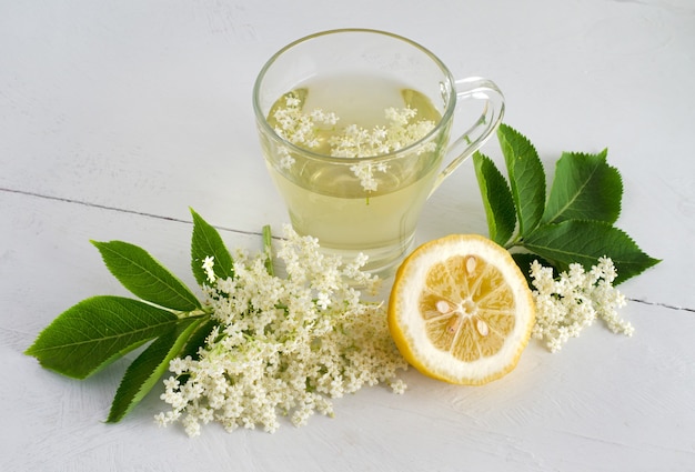 Boisson fraîche de fleur de sureau avec du citron tranché sur un tableau blanc. Vue de dessus.