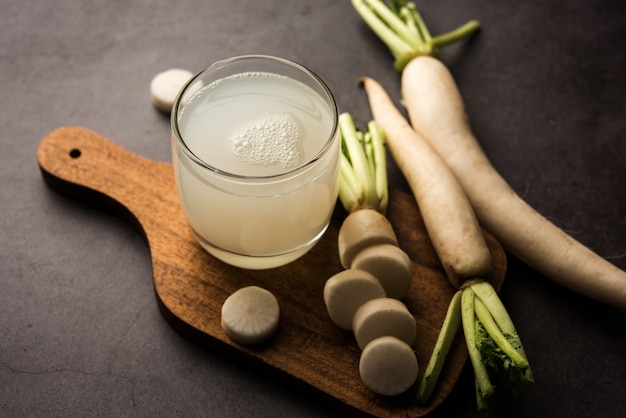 Photo boisson fraîche saine de jus de daikon ou d'extrait de mooli dans un verre avec la mule crue