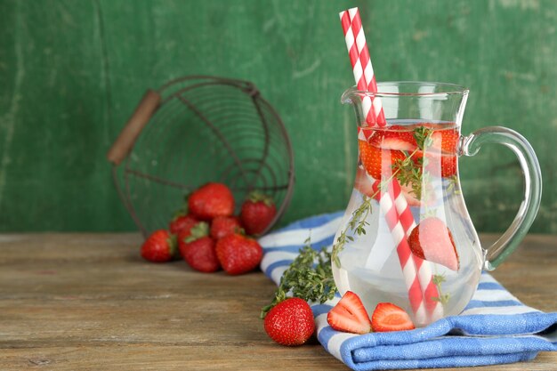 Boisson fraîche savoureuse avec des fraises et du thym, sur bois