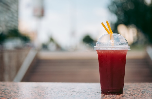 Boisson à la framboise rouge dans un verre en plastique avec une paille