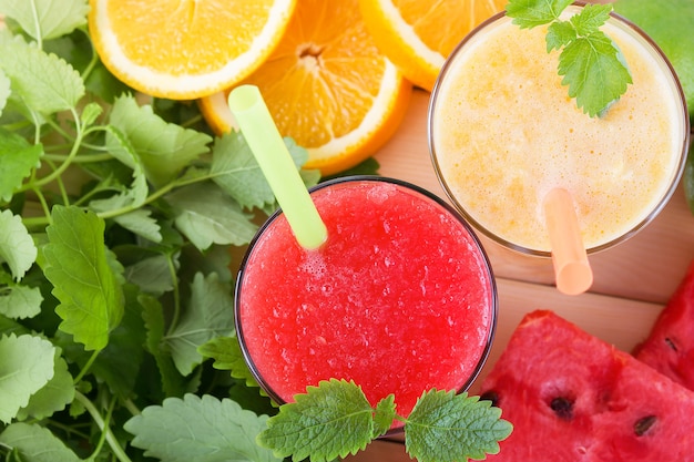 Photo boisson froide d'été smoothie pastèque orange vif juteux rouge jaune cocktail de fruits avec de la glace