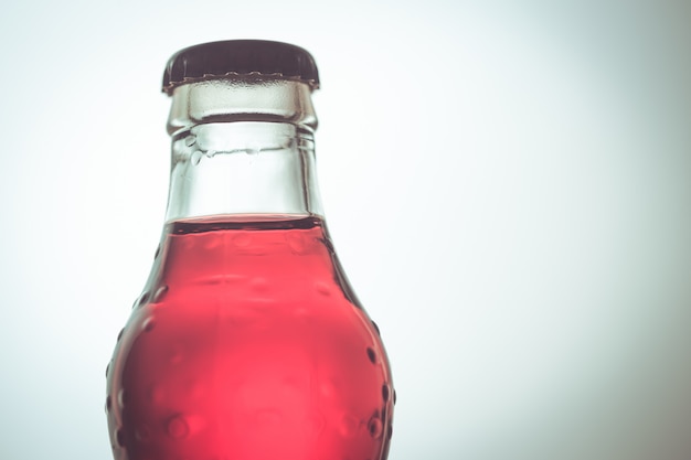 Boisson gazeuse, couleur rouge en bouteille de verre.