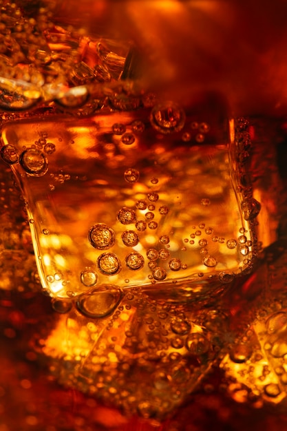 Boisson gazeuse froide sur des glaçons dans un verre en gros plan