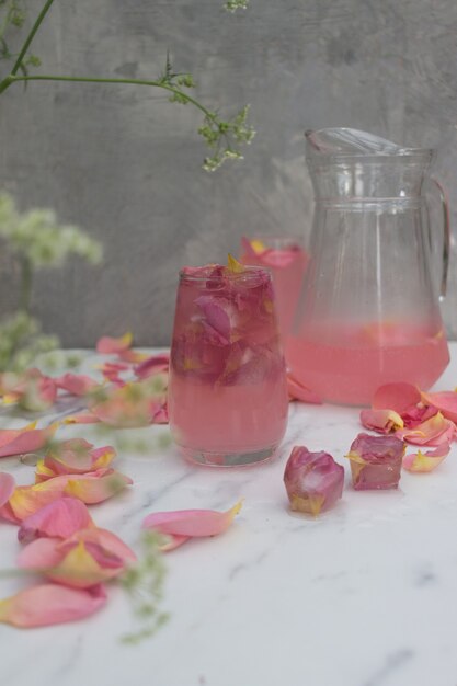 une boisson avec des glaçons avec des fleurs dans un verre