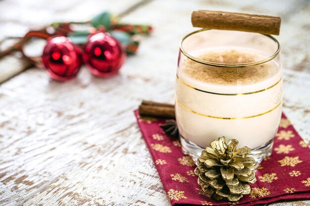 Boisson d'hiver à base d'œufs, de liqueur et de cannelle, appelée lait de poule, coquito ou lait d'Auld Man, décorée de noix et de fruits secs