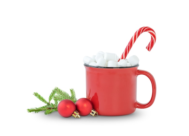 Photo boisson de noël dans une tasse rouge avec des bonbons à la guimauve et des ornements de noël isolés sur blanc