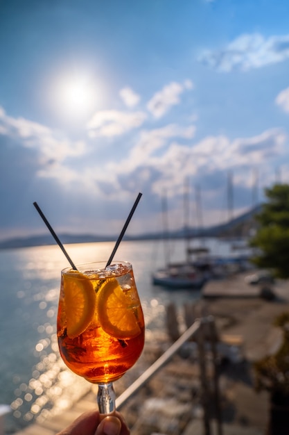 Boisson à l'orange ou cocktail debout à la petite table du restaurant ou du café avec fond de mer