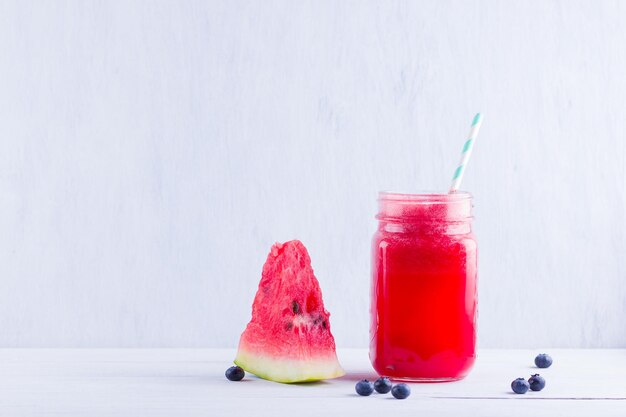 Boisson à la pastèque dans des jarres de maçon avec des tranches de pastèque Smoothies à la pastéque et aux bleuets