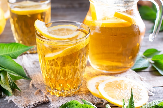 Boisson rafraîchissante, thé glacé avec quartiers de citron vert en verre sur une table en bois. Boissons d'été. Boissons non alcoolisées